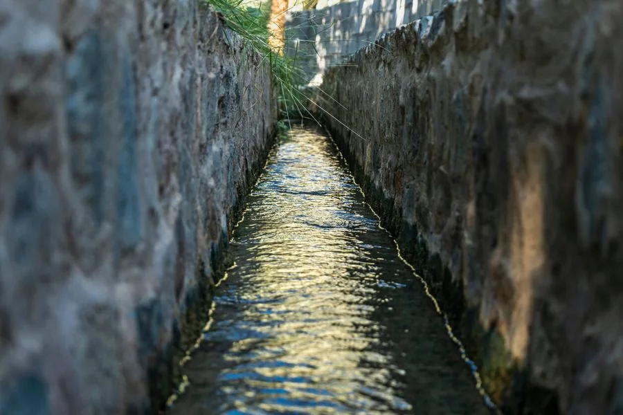 Acqua in un canale irriguo tradizionale falaj — UN Water Conference. Immagine tematica.