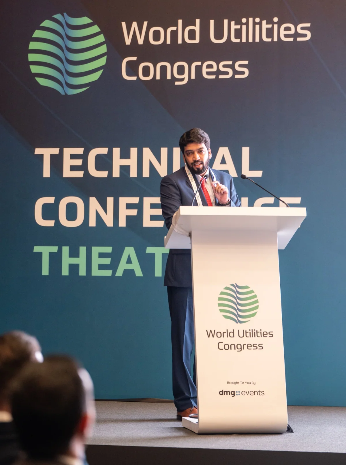Prelegent z mikrofonem — World Utilities Congress 2025. Zdjęcie archiwalne.