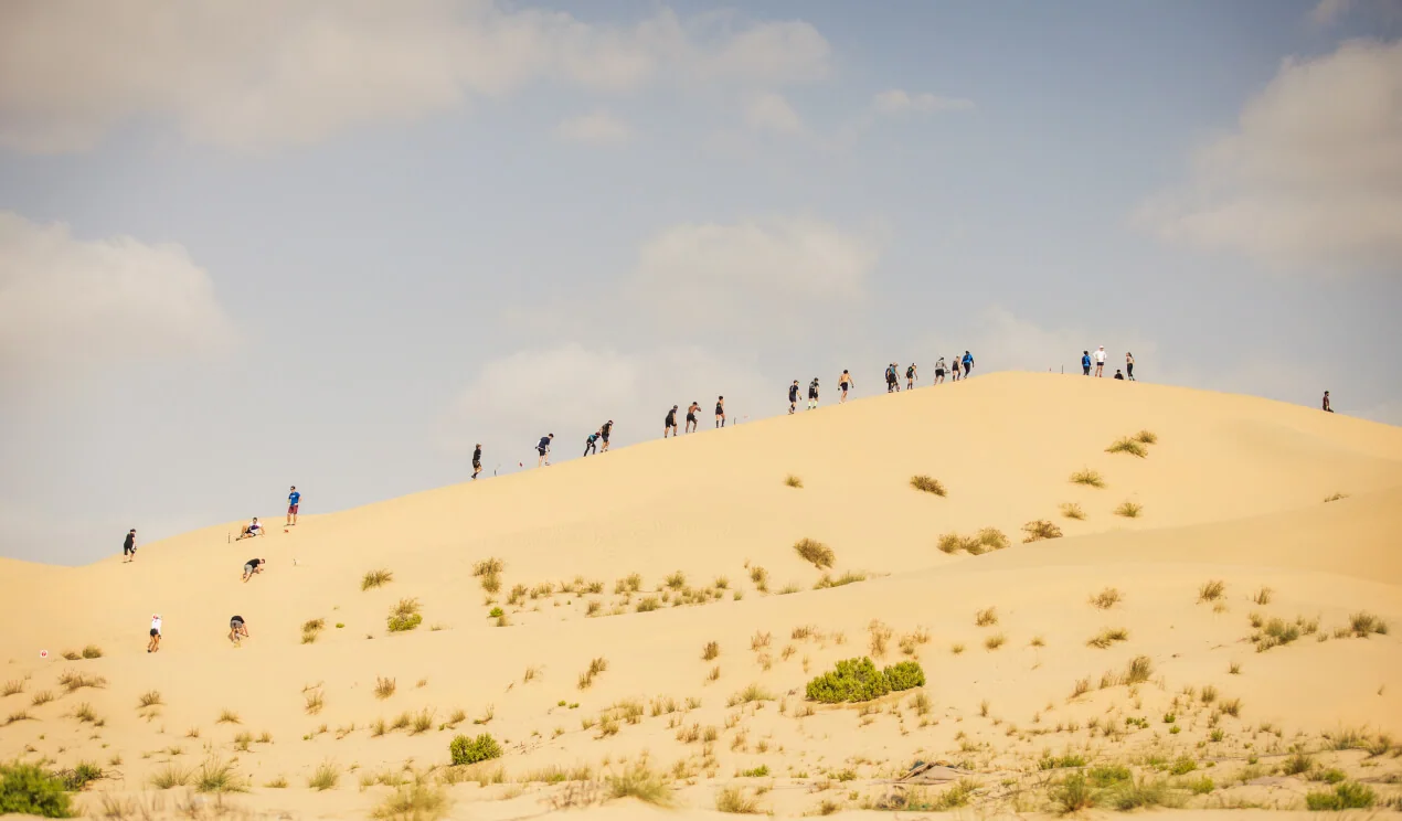 Des participants gravissent une dune. Archives Spartan à Abou Dabi.