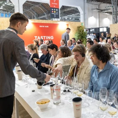 Uczestnicy przy stole degustacyjnym Barcelona Wine Week; archiwum.