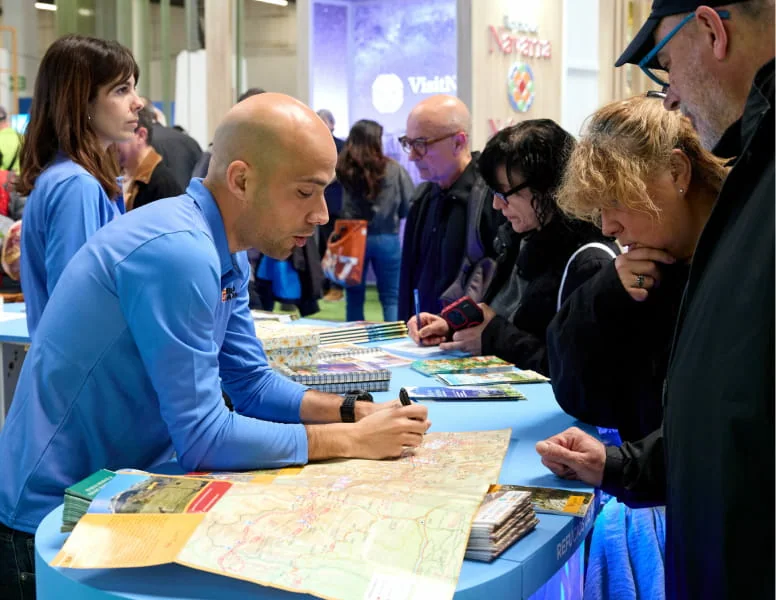 A consultation beside a map at B-Travel; archive.