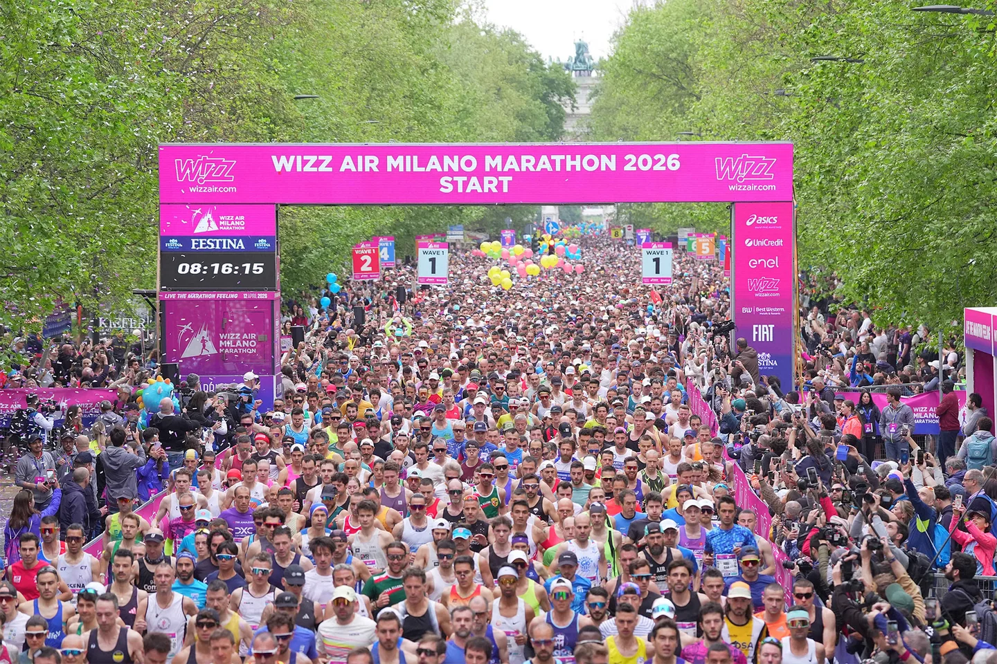 Runners beneath the pink start arch of the 2026 marathon.
