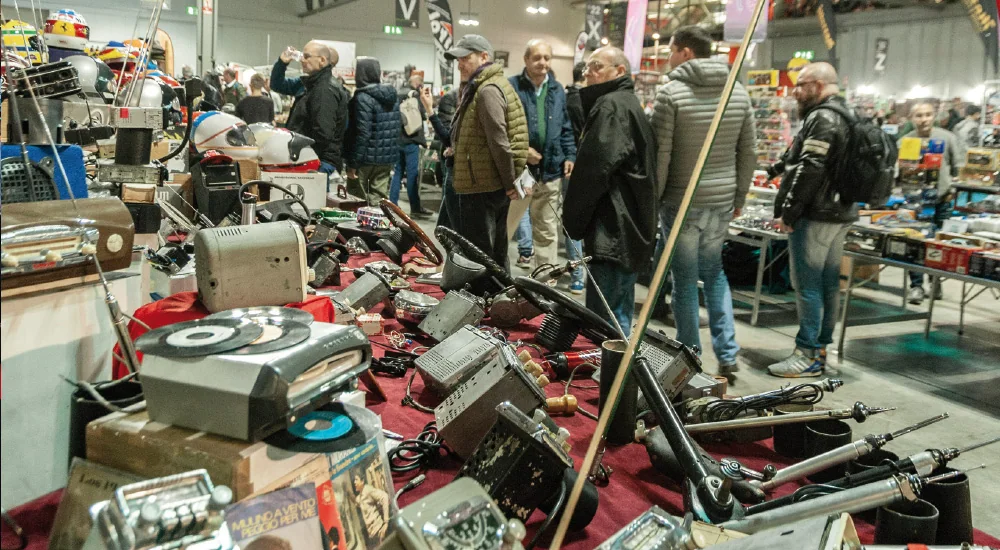 Visitatori ai tavoli con ricambi d’epoca e autoradio.