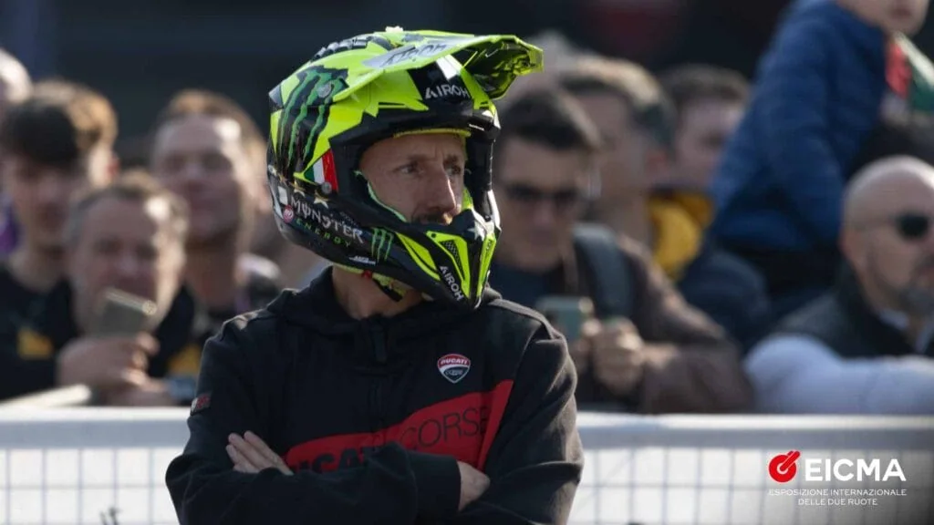 Un participant portant un casque de moto devant le public.