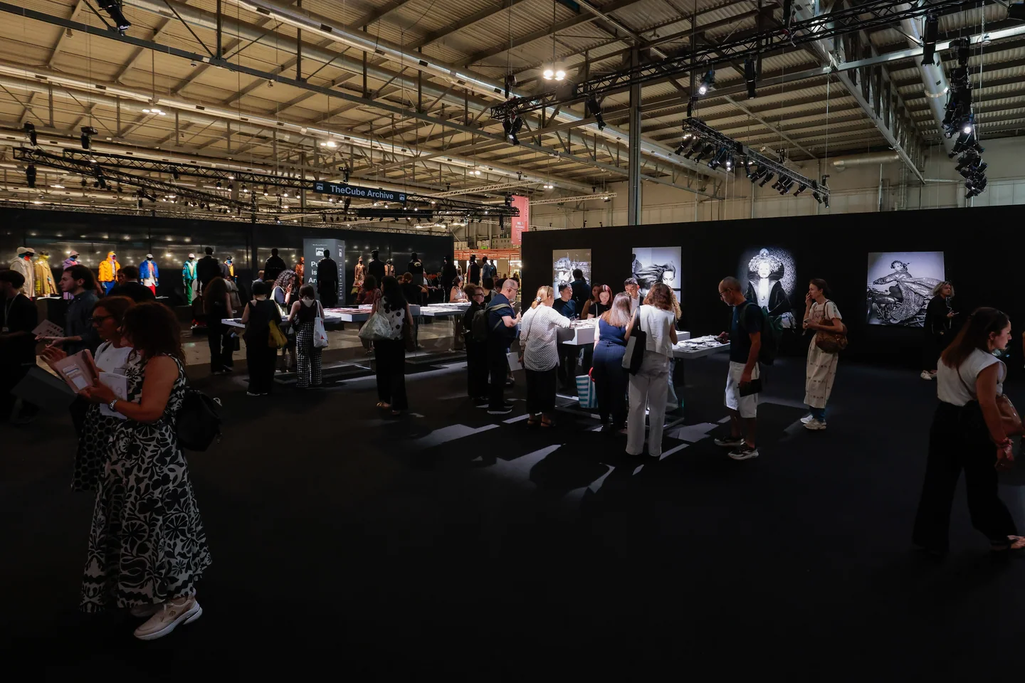 Besucher prüfen Materialmuster an Tischen auf der Milano Unica.