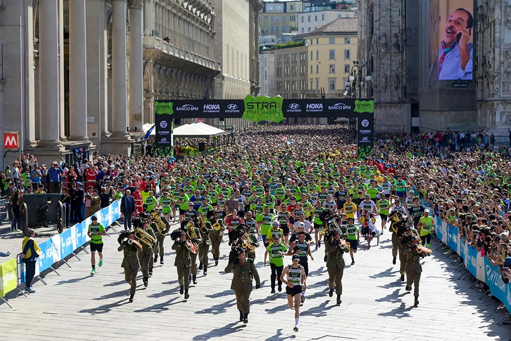 Runners and a marching band by the start arch beside the cathedral.