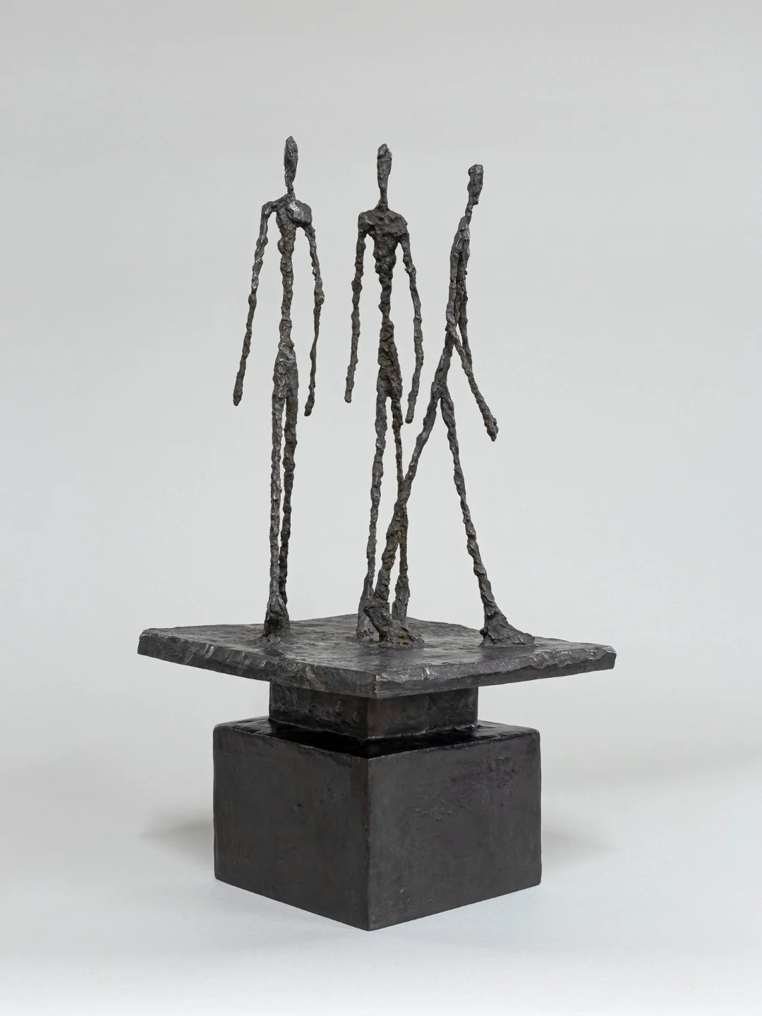 Three standing figures by Giacometti, pictured in the Milan exhibition materials.