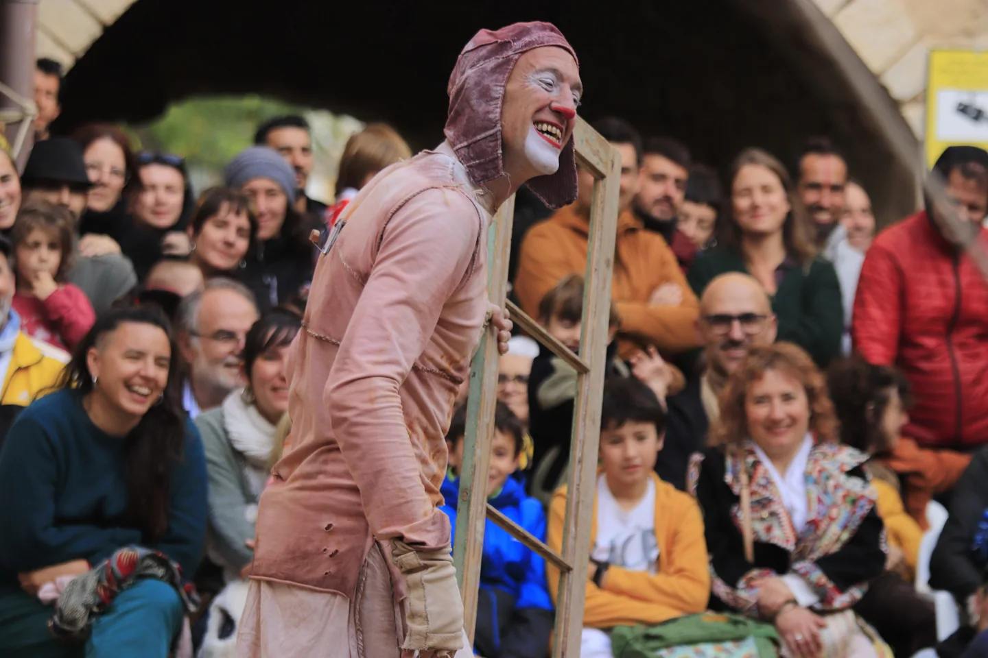 Un clown con una cornice di finestra davanti al pubblico: foto promozionale dello spettacolo per famiglie fOrat.