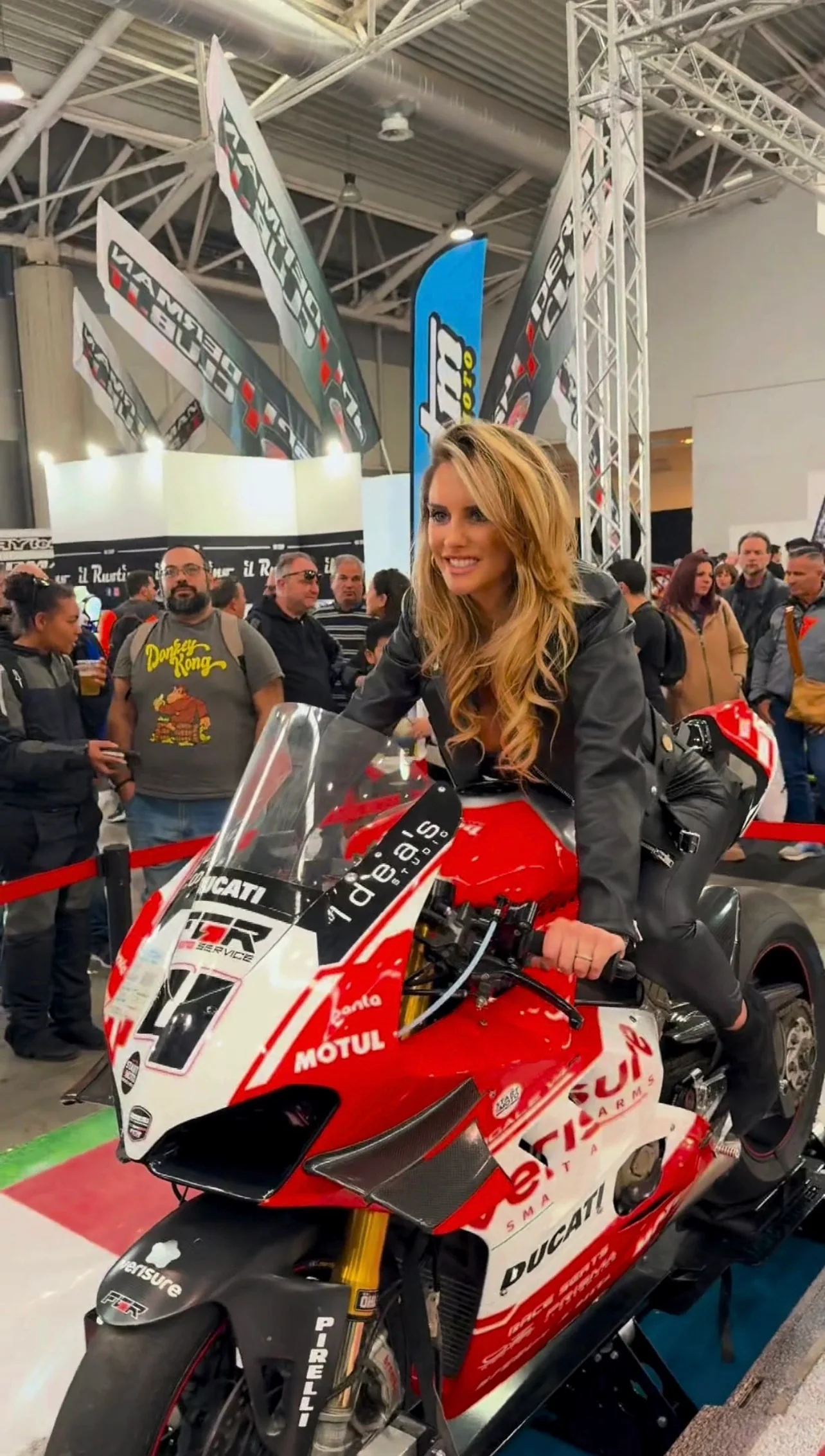 Жінка на червоному мотоциклі серед відвідувачів; архівне фото Motodays.