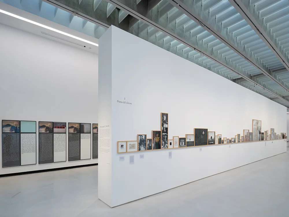Fotografii și texte înrămate pe un perete lung al expoziției Sophie Calle la MAXXI.
